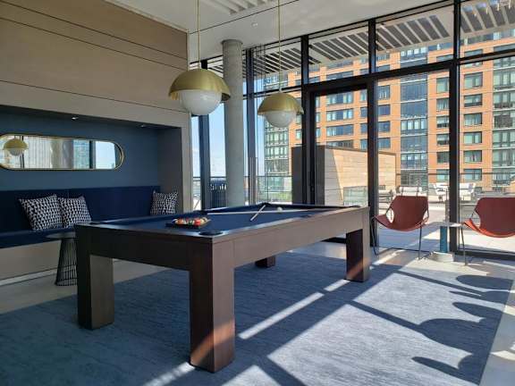 a pool table in a room with large windows at The Lively, New Jersey, 07302