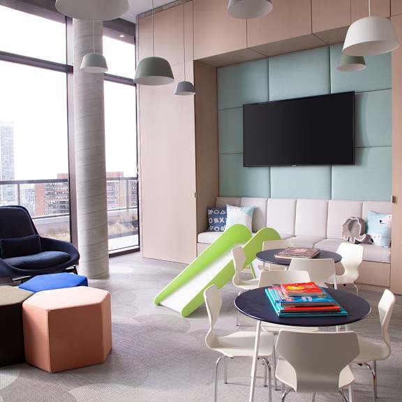 a living room with a table and chairs and a television at The Lively, Jersey City New Jersey