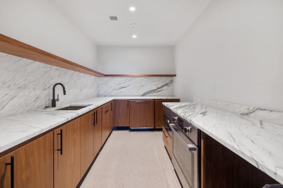 a kitchen with marble counter tops and wooden cabinets at The Paxton, Brooklyn, 11201