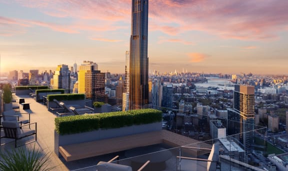 a rooftop terrace with a view of the city and a sunset at The Paxton, Brooklyn, NY 11201