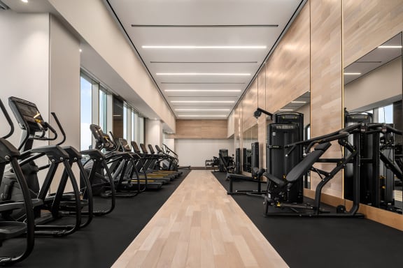 a row of exercise machines in a gym at The Paxton, Brooklyn, NY