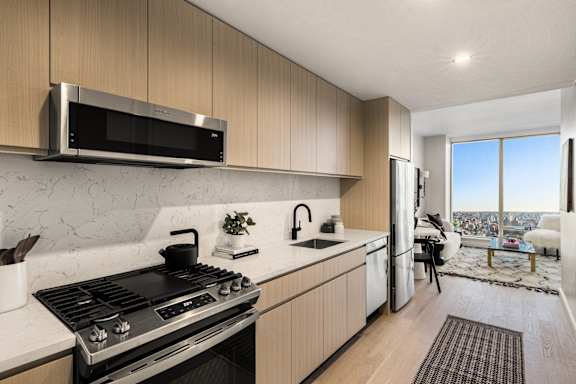 A modern kitchen with a stove top oven and a microwave above it.
