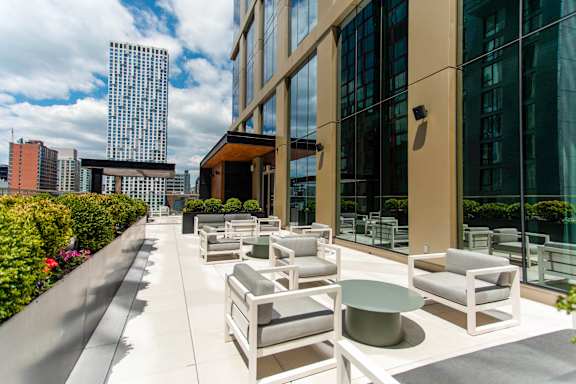 A patio with white furniture and a building in the background.