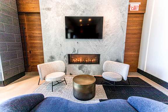 A living room with a fireplace and a flat screen TV mounted on the wall.