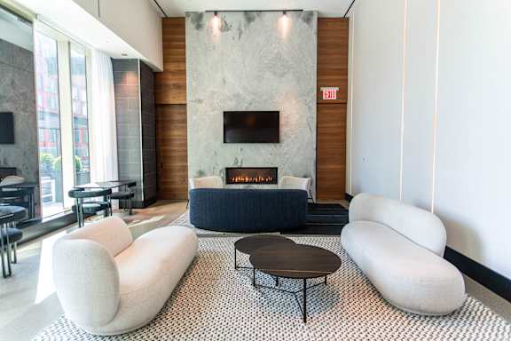 A modern living room with a fireplace and a black coffee table.