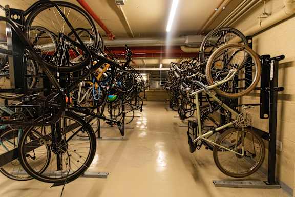 A bike rack full of bicycles in a hallway.