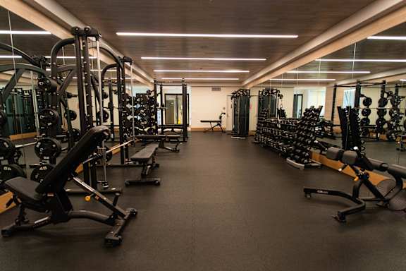 A spacious gym with a variety of equipment including treadmills, weights, and exercise machines.