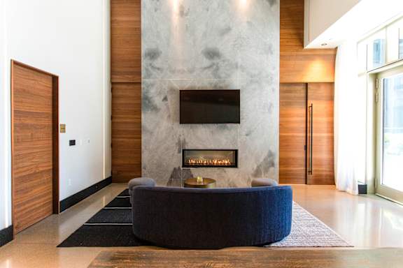 A modern living room with a fireplace and a flat screen TV mounted on the wall.