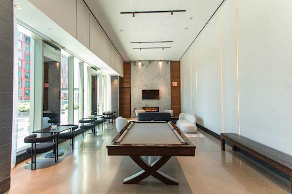A billiard table is in the middle of a room with a fireplace.