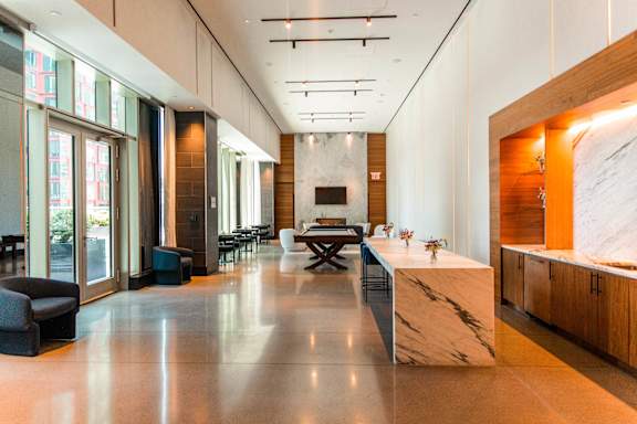 A modern kitchen with a marble countertop and a long table.