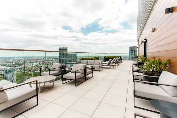 A patio with chairs and a table overlooking a cityscape.