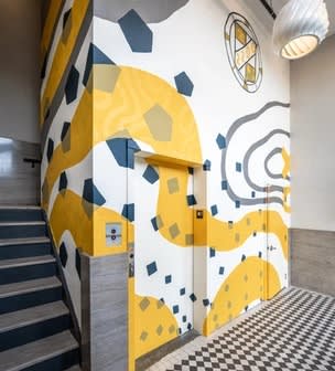 a building with a yellow and white mural on the side of it at The 22 Apartments, St. Louis, 63103
