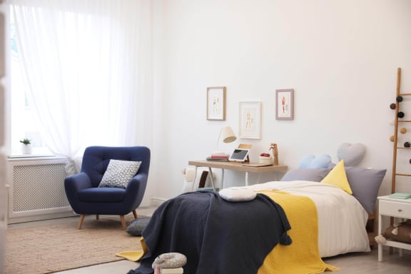 a bedroom with a bed and a blue chair