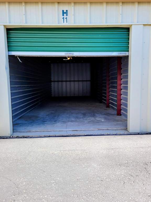 A garage door with a green roller shutter and a sign that says H 11.