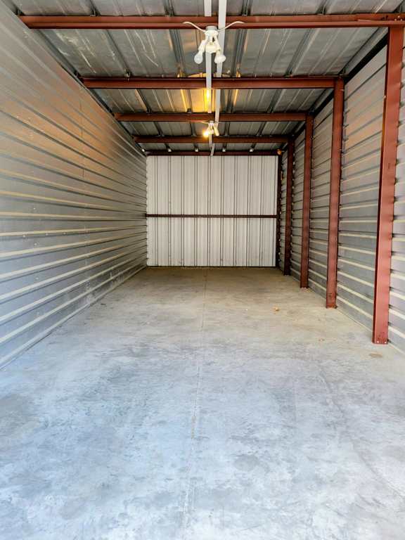 A long, narrow storage space with a metal roof and walls.