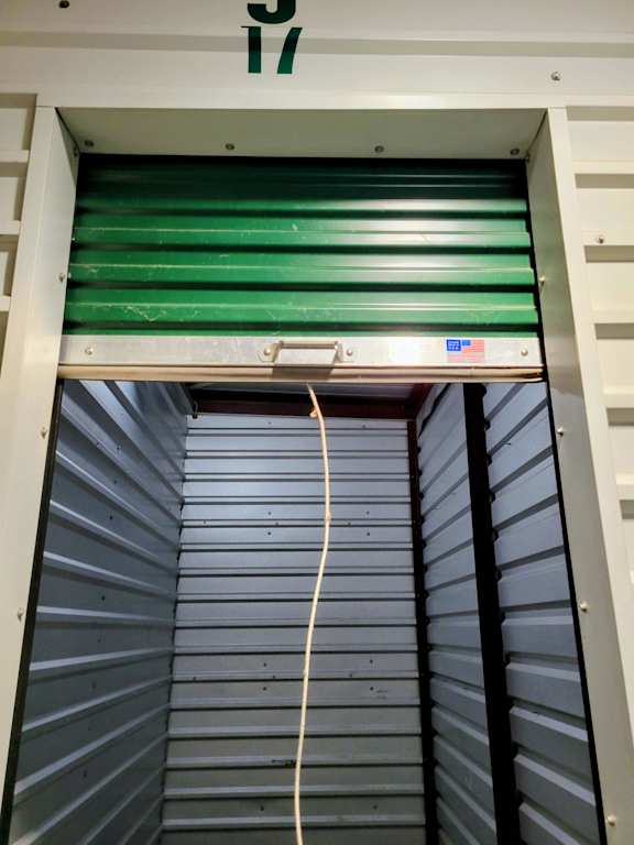 A green shutter is open to a storage unit.