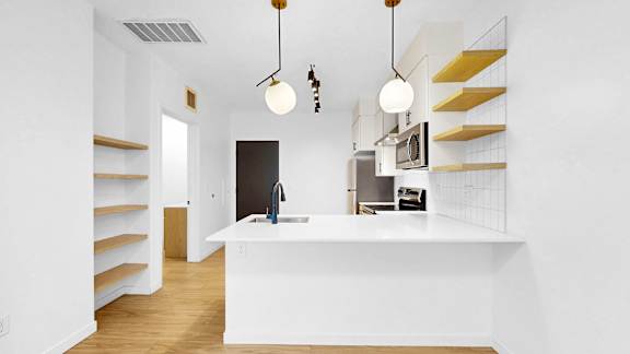 A kitchen with a white counter and a black refrigerator.