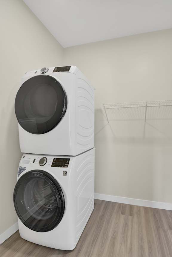 Two white front load washing machines in a laundry room.