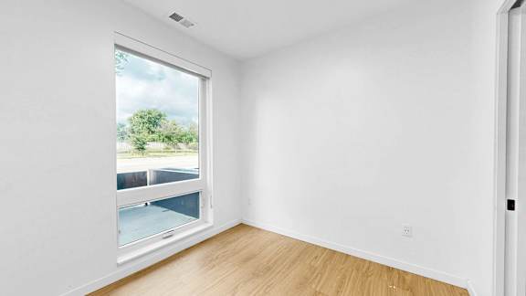 A room with a window overlooking a parking lot.
