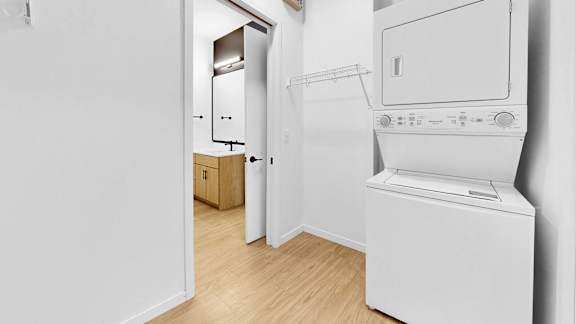 A white washing machine sits in a laundry room.