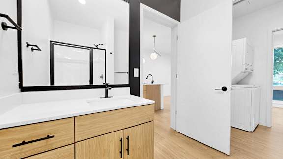 A bathroom with a sink, mirror, and wooden cabinets.