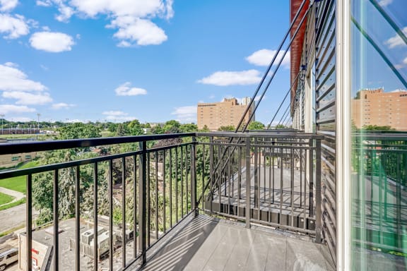the balcony has a view of the city and the trees