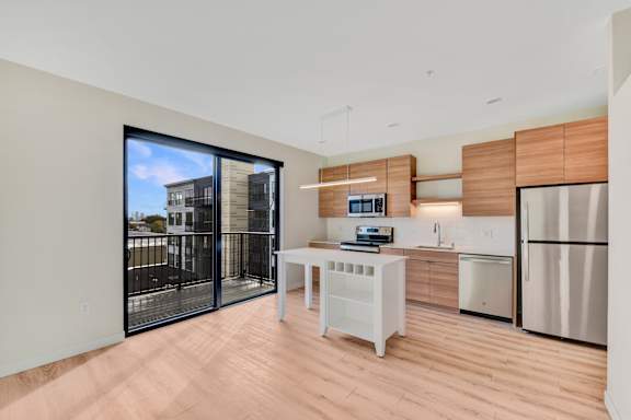 A modern kitchen with a white table and a refrigerator.