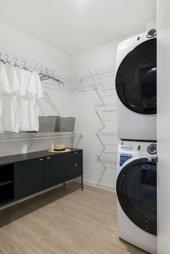 a washer and dryer in a laundry room with a counter and a closet