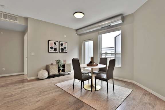 A dining room with a table and chairs.