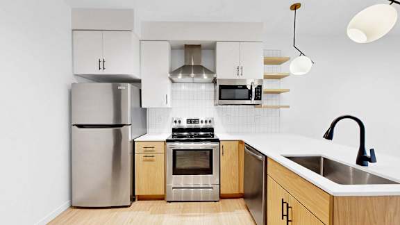 A modern kitchen with wooden cabinets and stainless steel appliances.