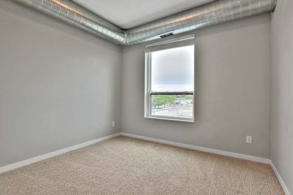 A room with a window and a view of the street outside.