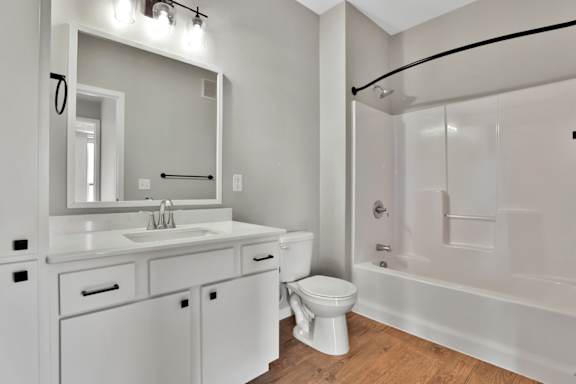 A white bathroom with a sink, toilet, and bathtub.