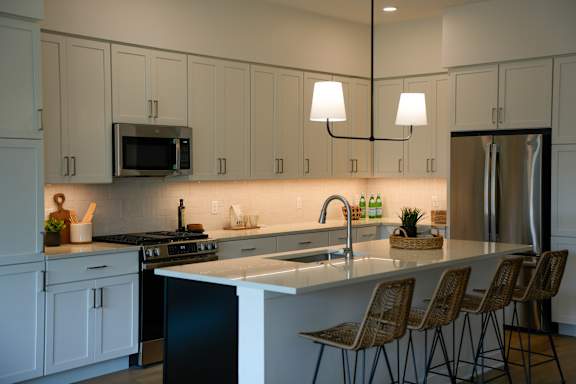 A kitchen with white cabinets and a black dishwasher.