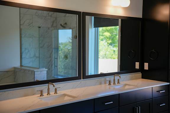 A bathroom with two sinks and a large mirror.
