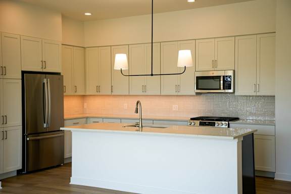 A kitchen with a white counter and a stainless steel refrigerator.