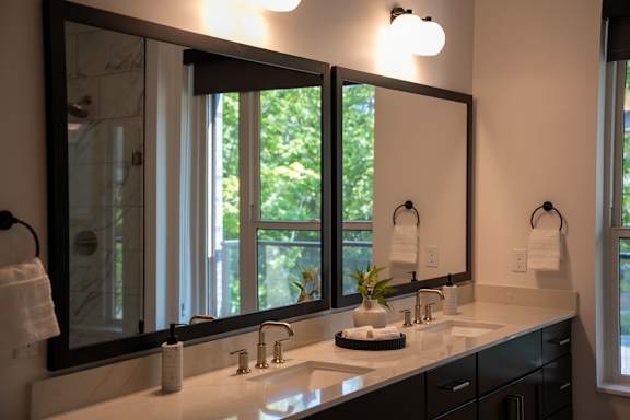A bathroom with a large mirror above a sink.