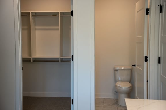 A white toilet in a bathroom with a white door.