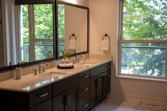 A bathroom with a large mirror and a sink with a white counter top.