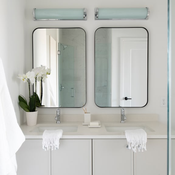 A bathroom with two sinks and a mirror above them.