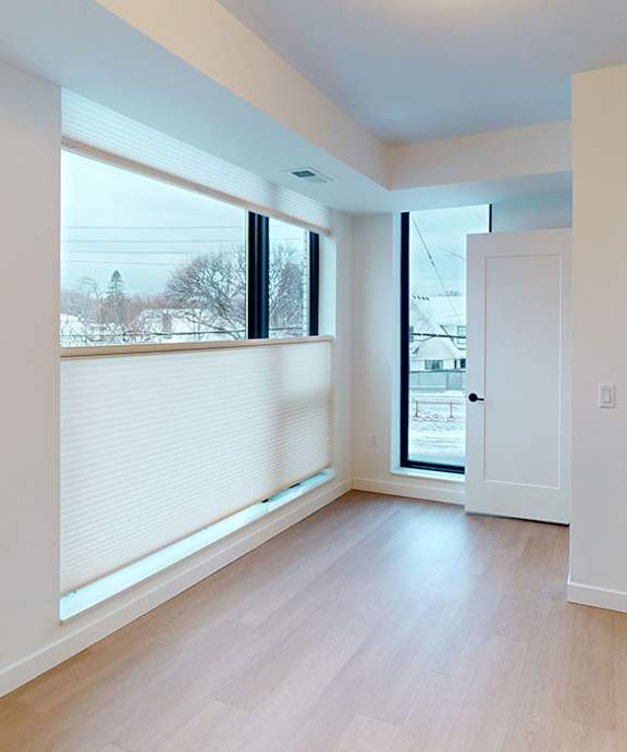 A room with a door and a window with blinds.