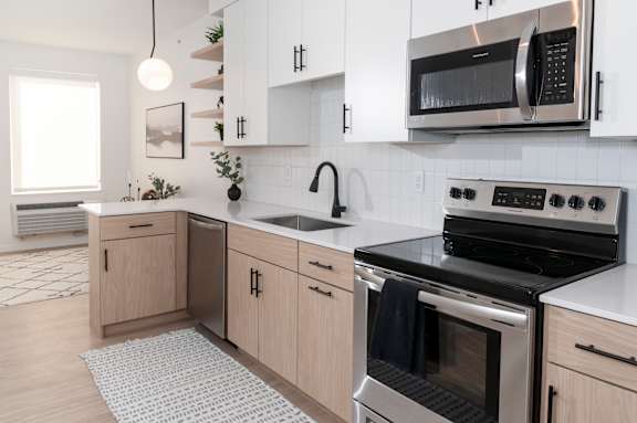 A modern kitchen with a stainless steel oven and microwave.