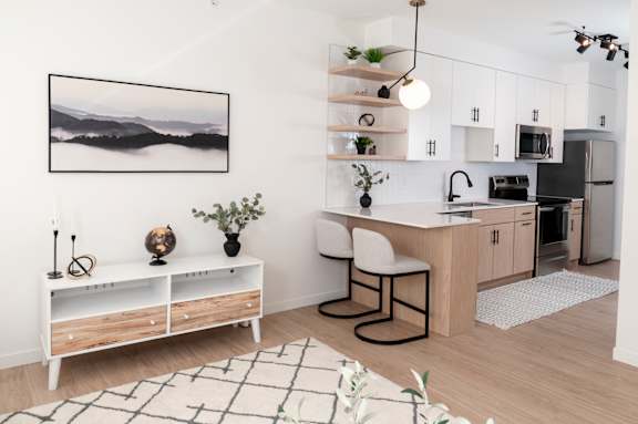 A modern kitchen with a wooden floor and white walls.