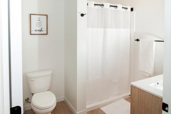 A white toilet sits next to a white sink in a small bathroom.