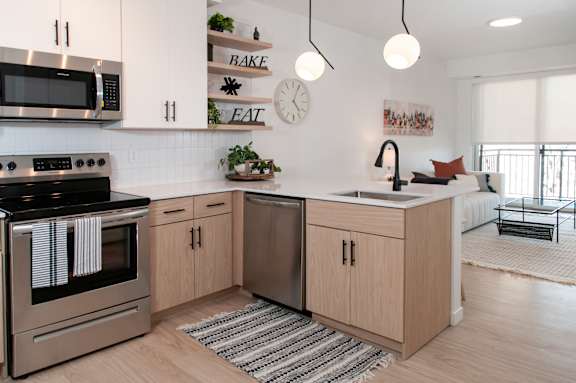 A modern kitchen with a stove, oven, and sink.