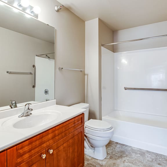 A white bathroom with a toilet, sink, and bathtub.