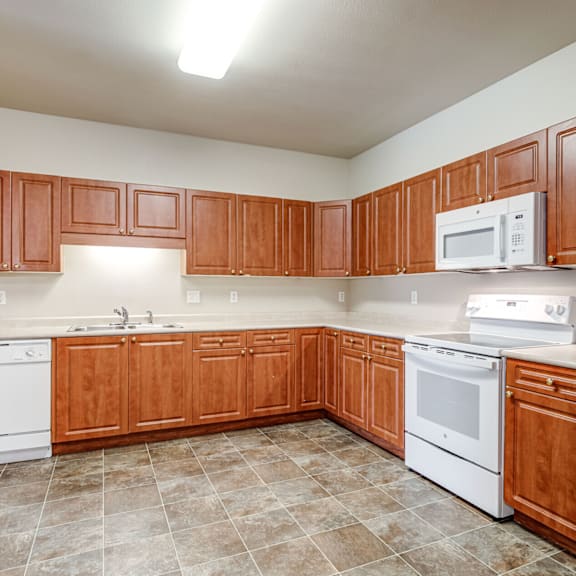 A kitchen with wooden cabinets and white appliances.