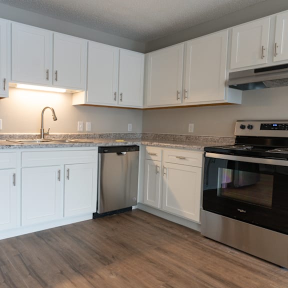 A kitchen with white cabinets and stainless steel appliances.