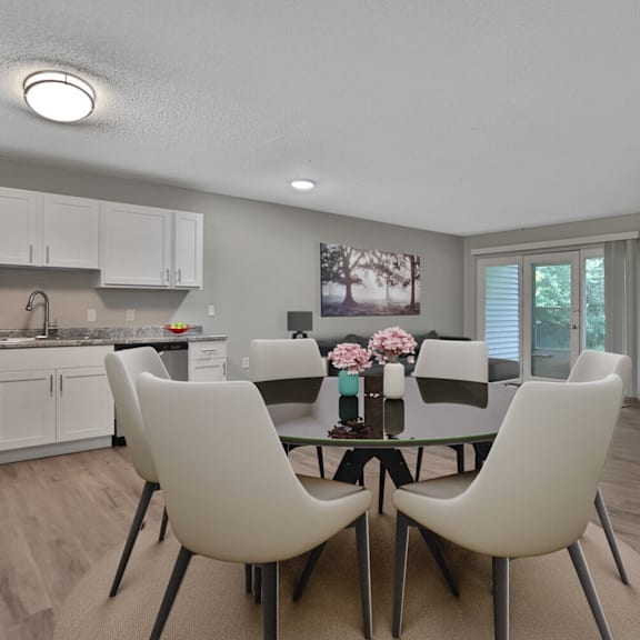 A modern dining room with a glass table and white chairs.