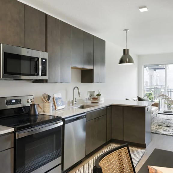 A modern kitchen with dark wood cabinets and stainless steel appliances.