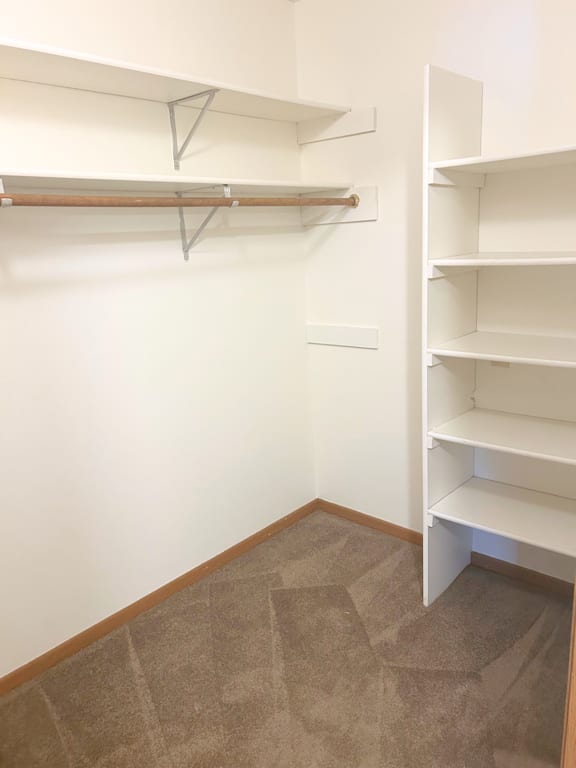 A room with a white wall and brown carpet.
